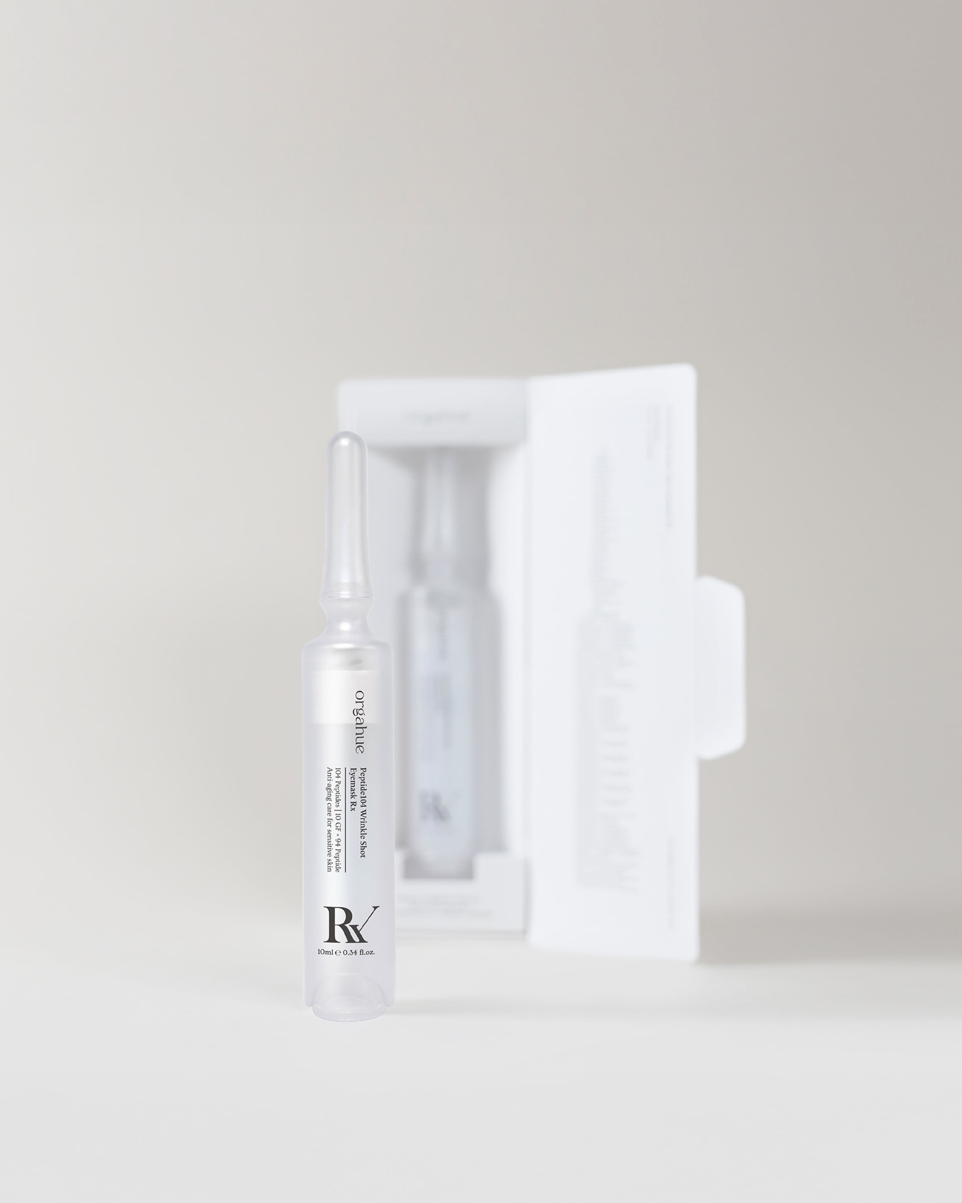 ORGAHUE Peptide 104 Wrinkle Shot Eye Mask Rx ampoule standing in front of its open white packaging